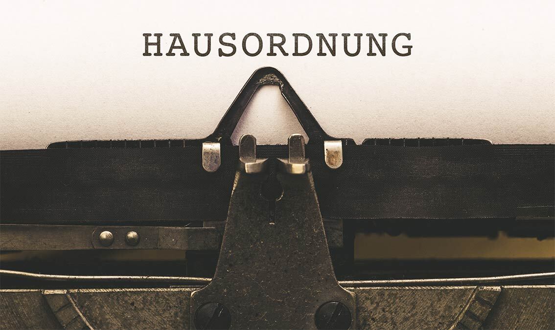 Auf einer Schreibmaschine wird die Hausordnung abgetippt.